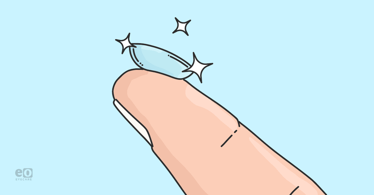 Closeup of a finger holding up a drug-eluting contact lens (DECL) with sparkles around it to represent technological innovations.